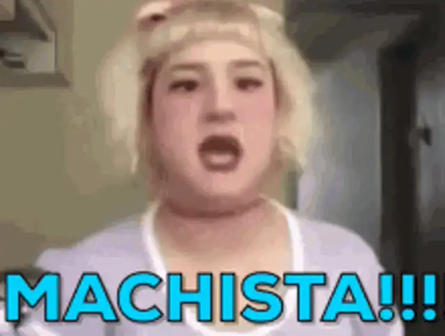 GIF animado de una persona con cabello rubio y top claro, con la boca abierta en expresión de sorpresa o enojo. En la parte inferior, un texto azul vibrante dice: "MACHISTA!!!".